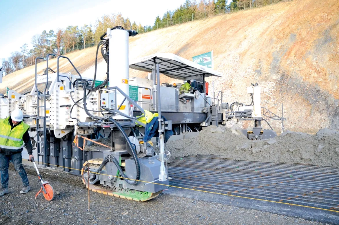 Assurant en une seule opération le coffrage et la vibration, la première machine à coffrages glissants (Wirtgen SP 1500) bétonne sur 17 cm d’épaisseur et sur 10 m de largeur. Au premier plan, le fil de guidage.