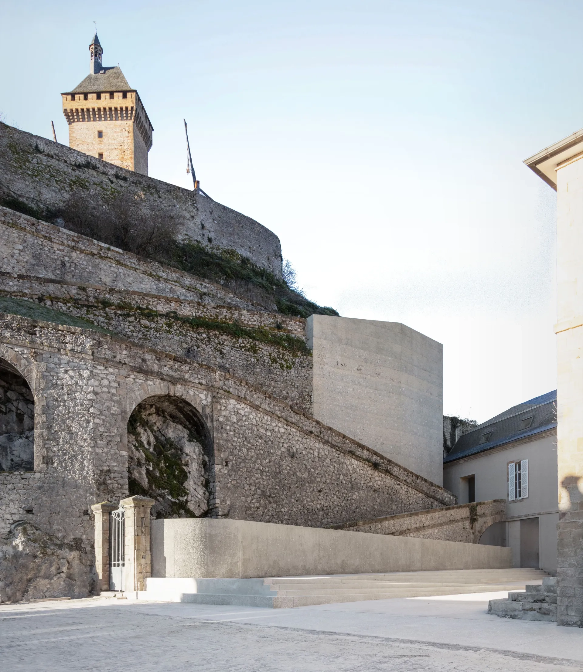 Par sa teinte, ses incorporations de pierre, sa texture bouchardée, le béton des ouvrages contemporains se fond dans le site. © Antoine Bonnafous