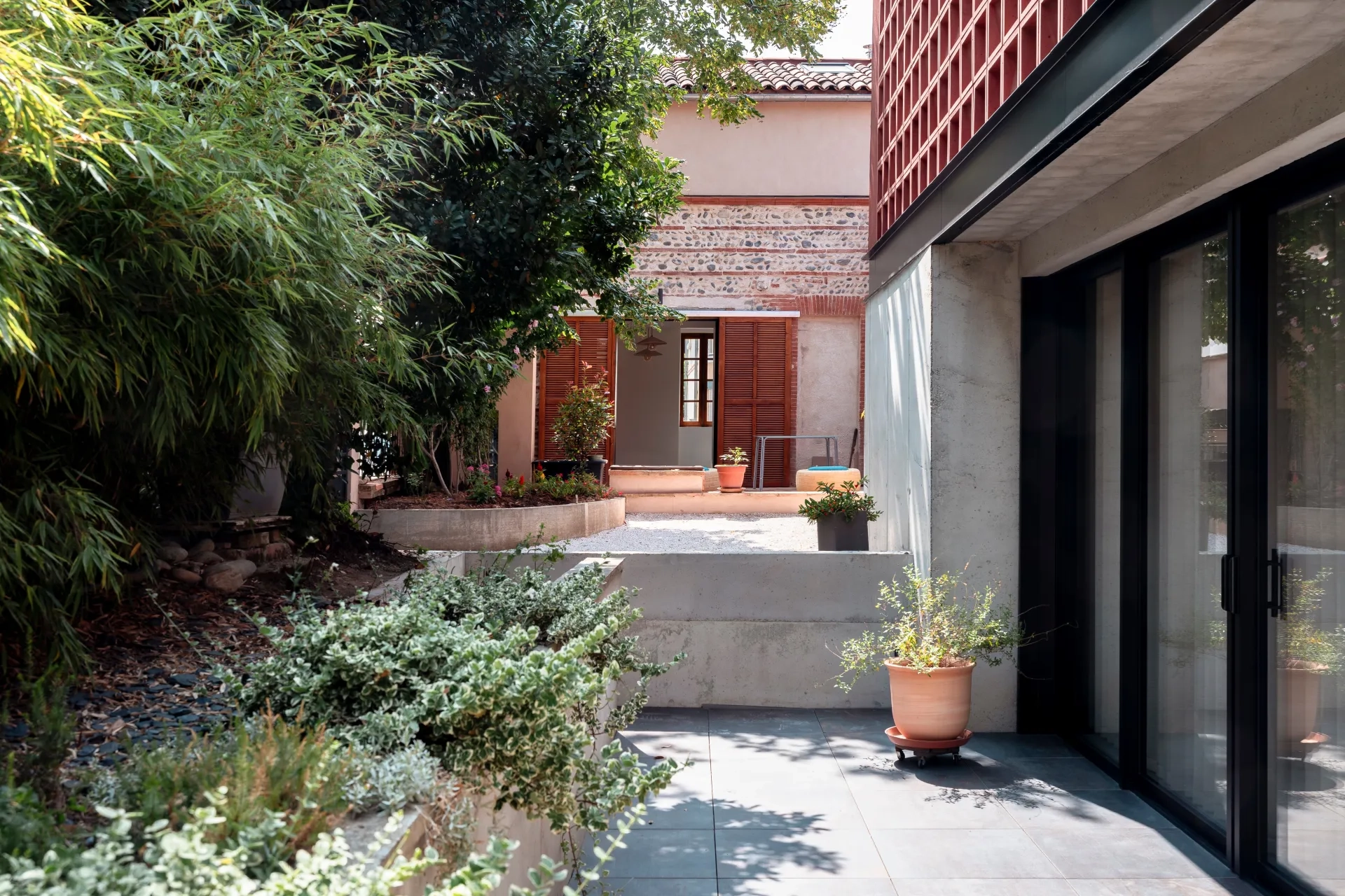 Le soubassement en béton banché se prolonge en terrasse à la manière d’un patio.