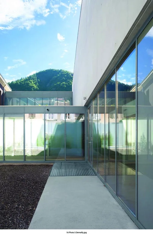 Un patio intérieur planté sépare le bâtiment existant de la nouvelle extension. un patio intérieur planté sépare le bâtiment existant de la nouvelle extension.