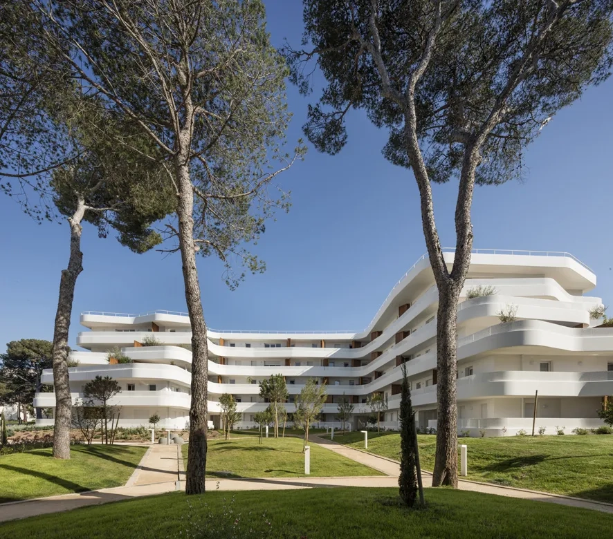 Les garde-corps des balcons filants s’enroulent autour de la façade et ondulent. Les garde- corps des balcons filants s’enroulent autour de la façade et ondulent.