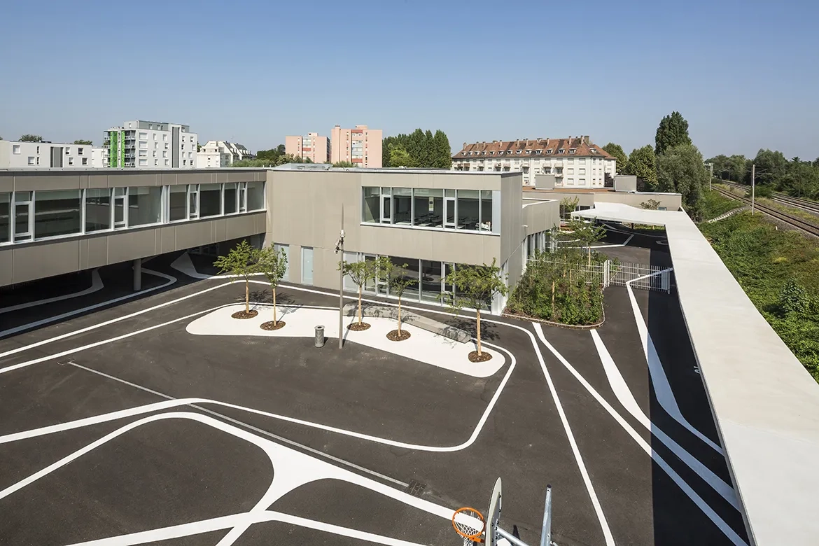 Les cours de récréation (ici, celle de l’école élémentaire) sont protégées des nuisances de voies ferrées par un mur écran. Les cours de récréation (ici, celle de l’école élémentaire) sont protégées des nuisances de voies ferrées par un mur écran.