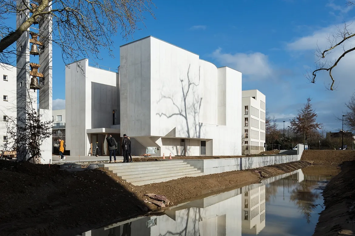 Le demi-cylindre de l’abside émerge en porte-à-faux de la façade est. Le demi-cylindre de l’abside émerge en porte-à-faux de la façade est.