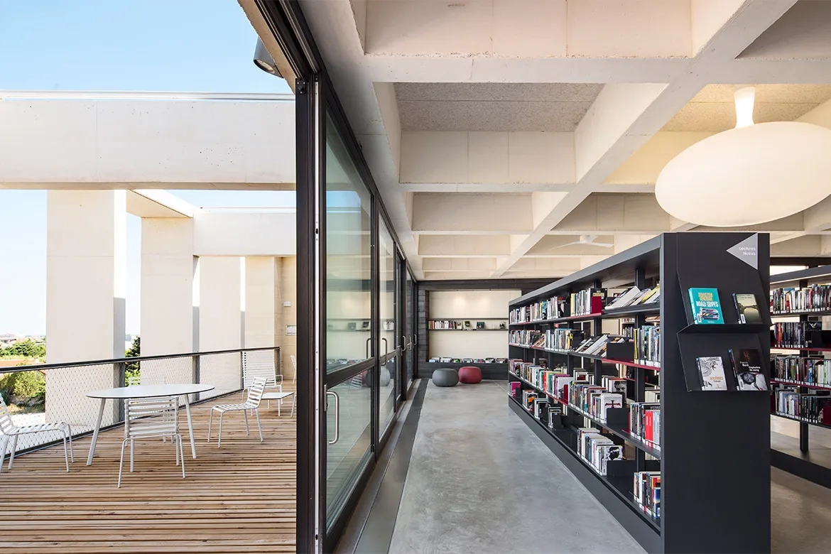 la salle de lecture du deuxième étage s’étend à l’extérieur en une terrasse d’où l’on aperçoit la mer.