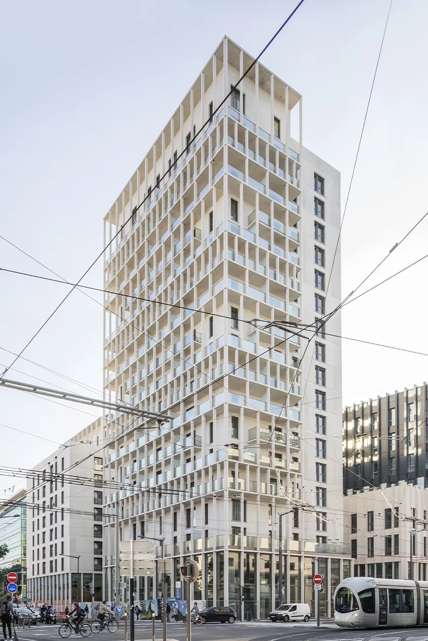 Composée de deux parallélépipèdes décalés, la tour de logements affiche un profil élancé.