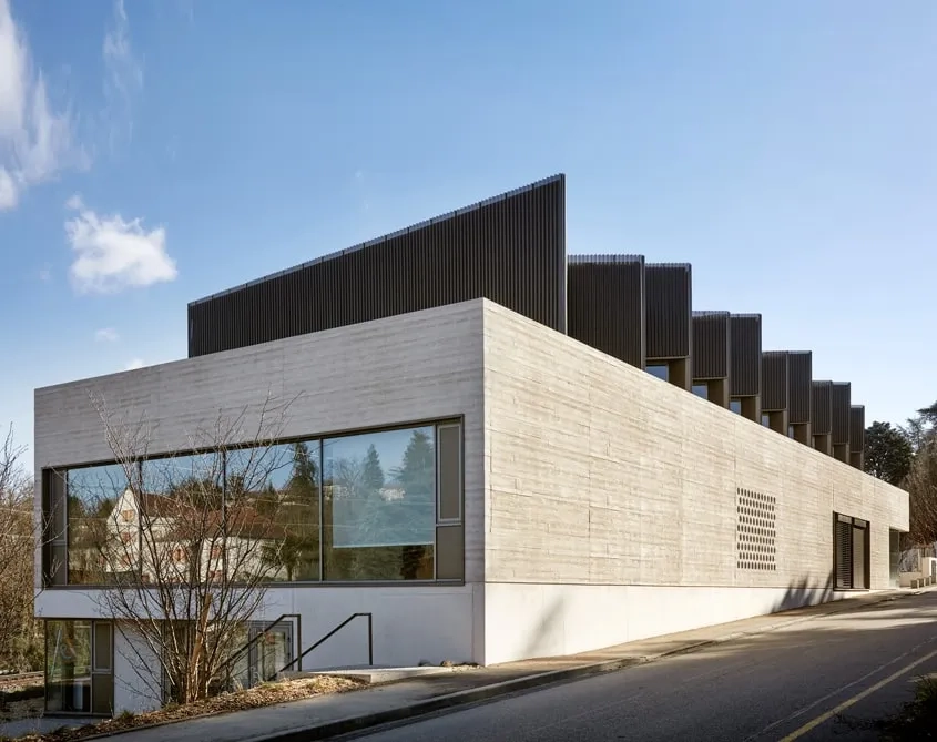 La maison des jeunes possède sa propre entrée au nord, en rez-de-jardin, dans la partie basse du volume en béton.