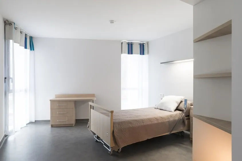 Vue d’une chambre avec deux fenêtres, l’une offrant la vue sur le grand paysage de la vallée et l’autre donnant sur l’environnement proche.