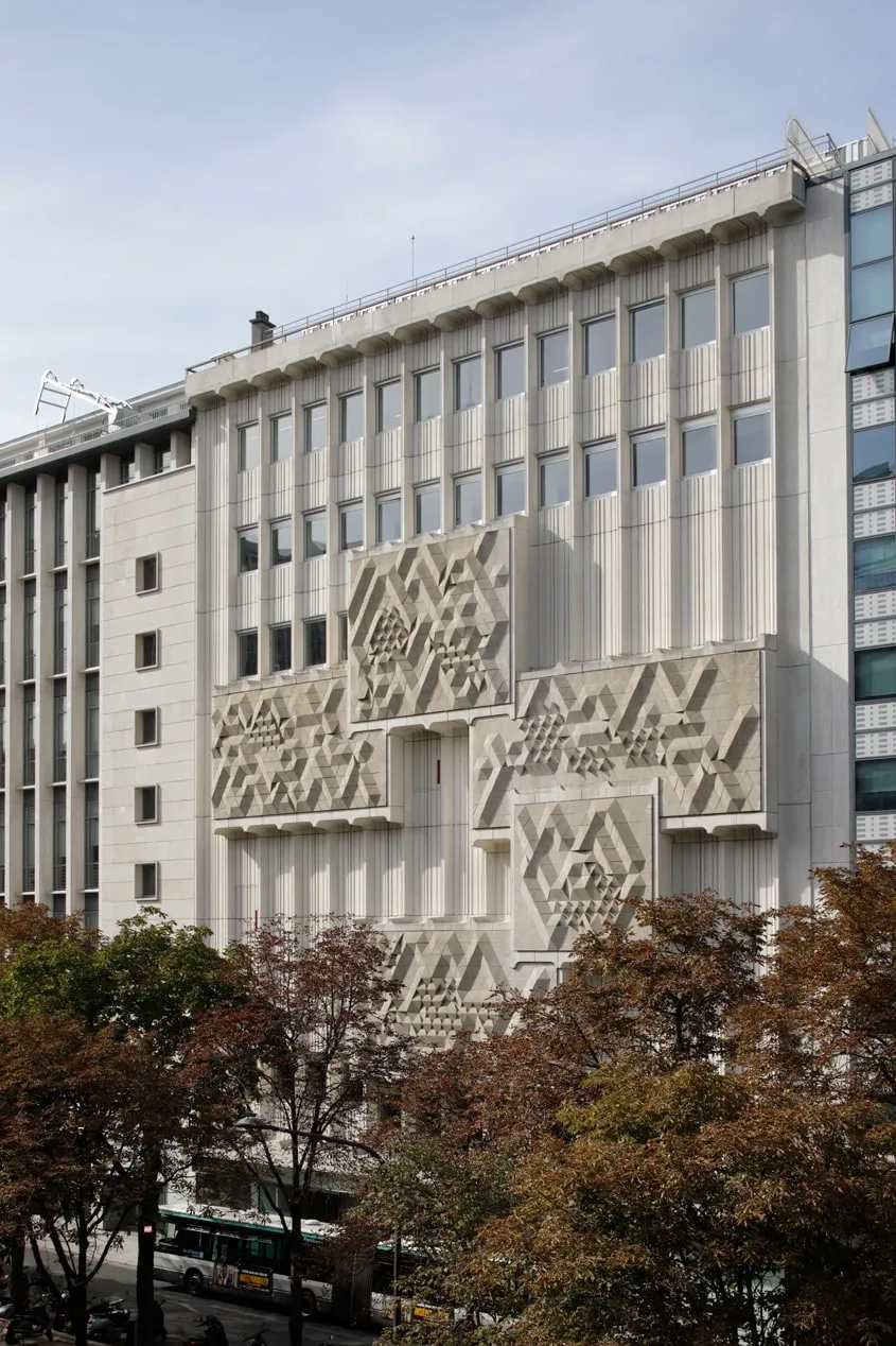La façade sur le boulevard est animée par le calepinage des panneaux préfabriqués en béton matricé et les grands reliefs sculptés évoquant la taille-douce d’un timbre à grande échelle.