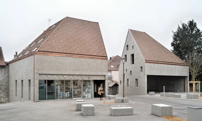 Bordant la place et tenant lieu de porte d’entrée, les deux nouvelles constructions forment un tout que l’on aurait scindé en deux.