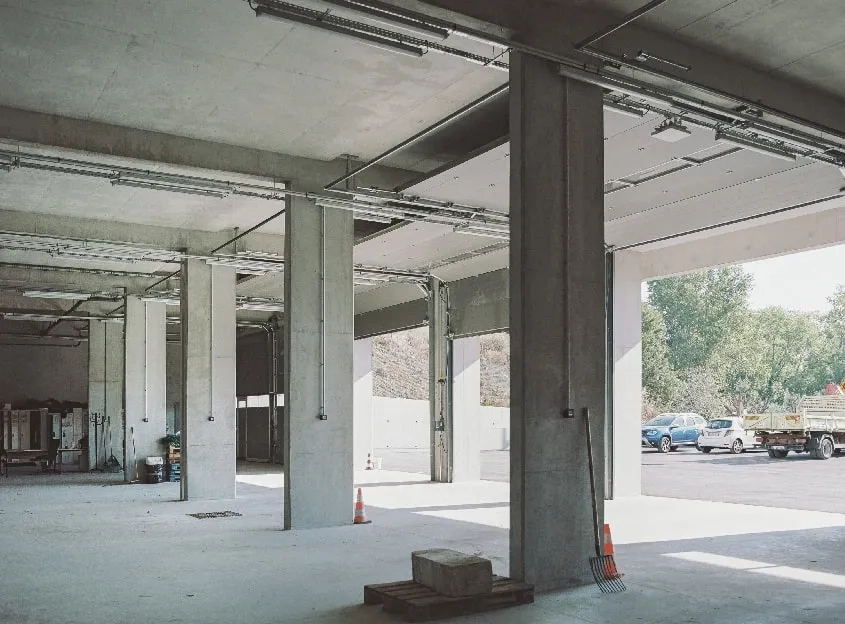 Vue sur le garage des véhicules d’intervention et des engins routiers ouvert sur la cour. Vue sur le garage des véhicules d’intervention et des engins routiers ouvert sur la cour.