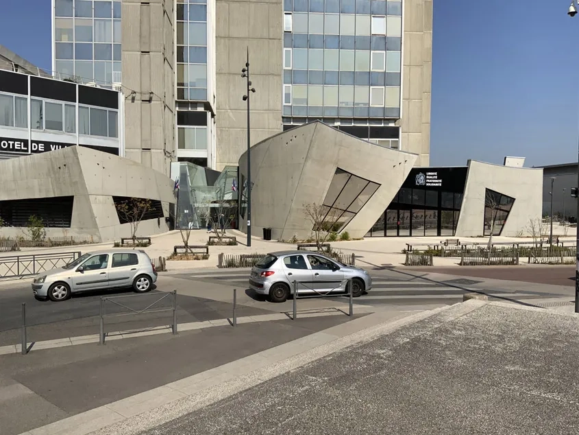 La façade principale de l’extension (côté sud) se caractérise par le jeu des surfaces gauches en béton qui la rythme et par sa composition en triptyque.