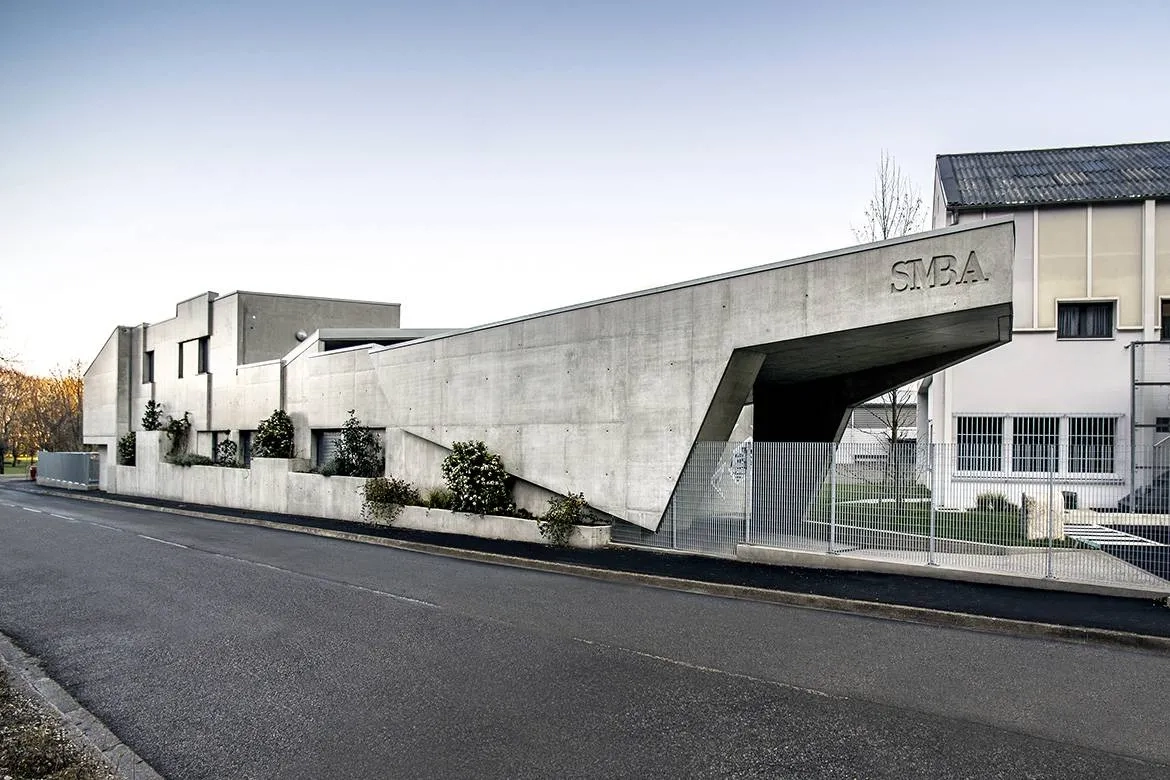 Le bâtiment se présente comme un monolithe de béton brut sculpté.