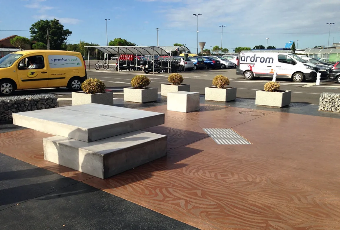 Leparvisdel'hypermarchéLeclerc fait l'objet d'un traitement résolument contemporain, avec du mobilier urbain en béton et une palette de trois couleurs : noir, gris et brun-rouge.