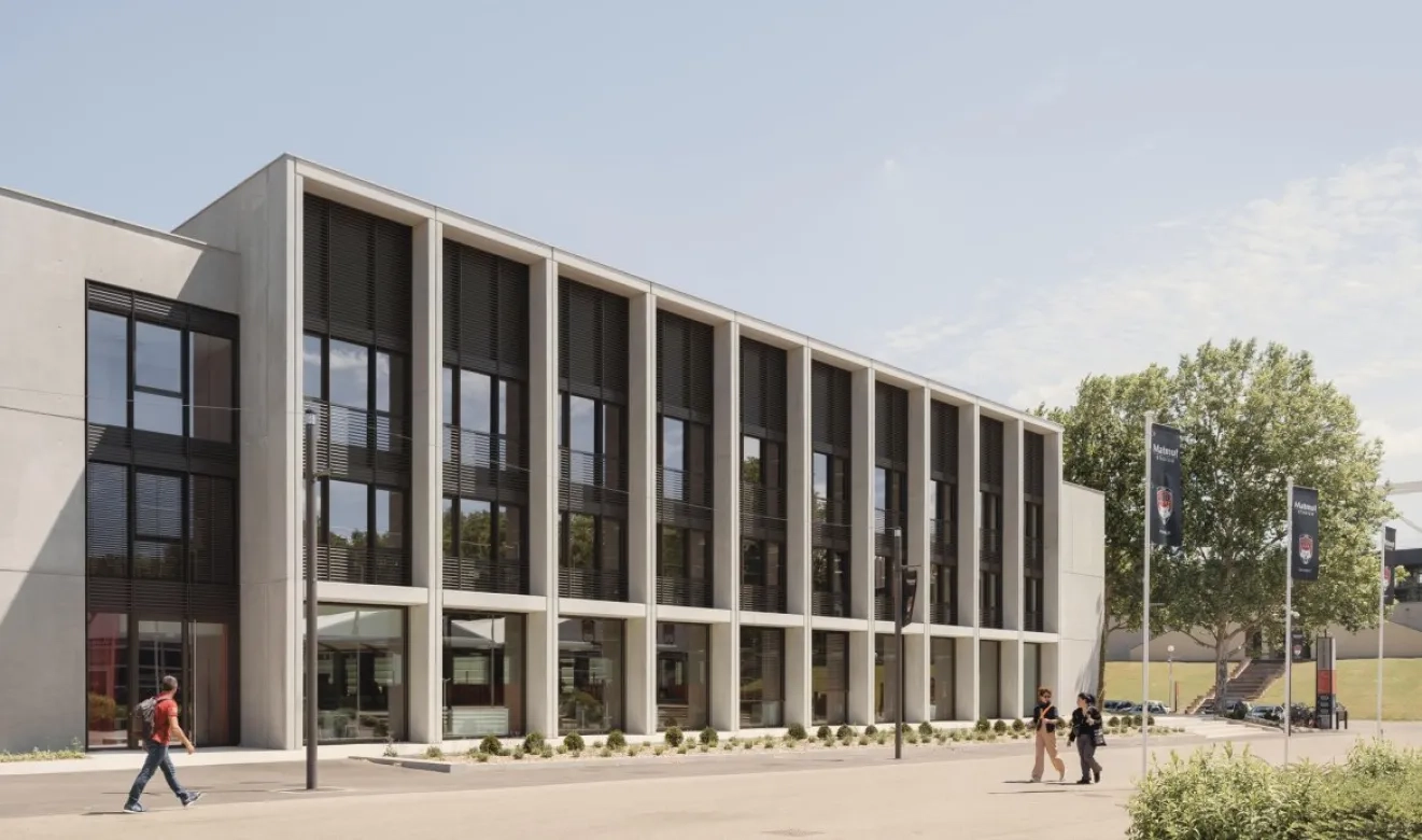 Avec leurs hauts poteaux assemblés de 4 et 10 m, les portiques en béton brut préfabriqués caractérisent la façade nord et rythment l’allée des Lions.