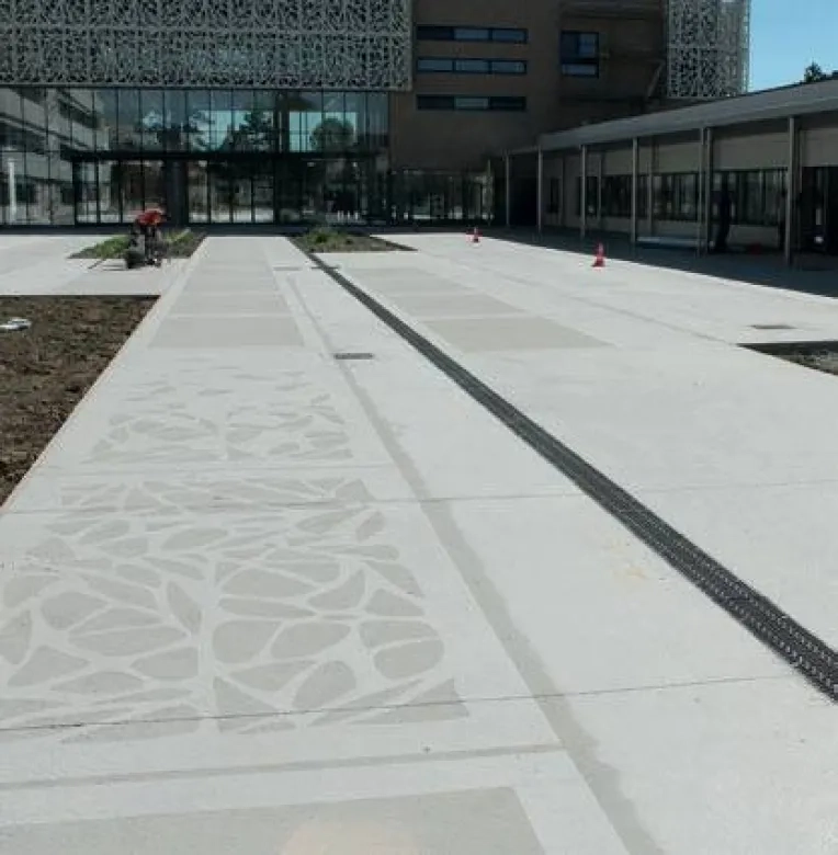 Sur les espaces extérieurs du collège, les motifs « façon moucharabieh » ont été réalisés en sablant le béton, recouvert d'un pochoir ou de matrices métalliques.